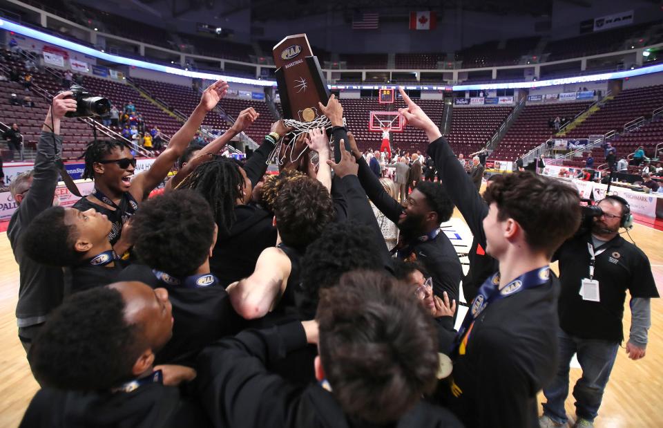 The Lincoln Park Leopards hoist up their trophy after defeating Neumann Goretti 62-58 in the PIAA 4A Championship game Thursday night at the Giant Center in Hershey, PA.