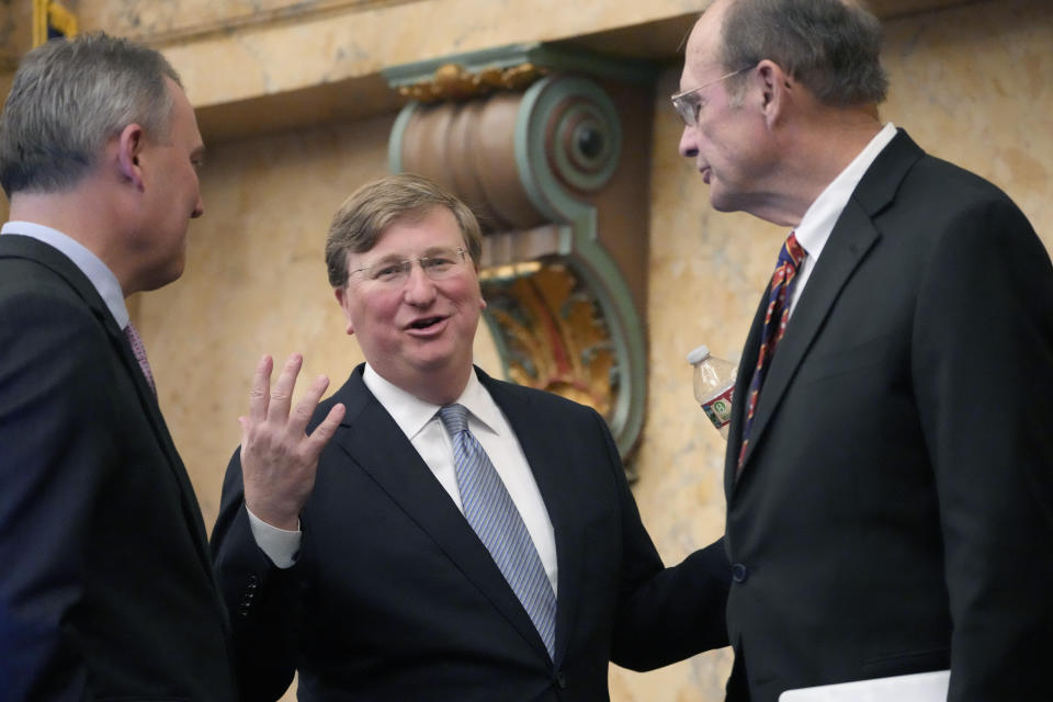 Mississippi Republican Gov. Tate Reeves, center, confers with Mississippi House Speaker Jason White, R-West, left, and Republican Lt. Gov. Delbert Hosemann, after his State of the State address to a joint session of the Mississippi State Legislature, Monday, Feb. 26, 2024, at the state Capitol in Jackson, Miss. (AP Photo/Rogelio V. Solis)