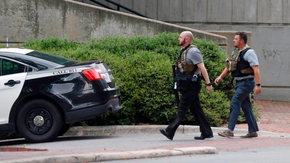 Two police officers move around a building on the campus of the University of North Carolina in Chapel Hill, N.C. Monday afternoon, Aug. 28, 2023 after a report of a “armed and dangerous person”.