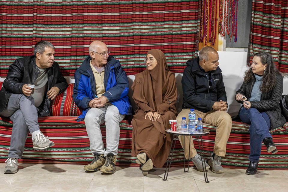 Huda Abu Obaid, center, and other guests, chat, while sitting. (Avishag Shaar-Yashuv for NBC News)