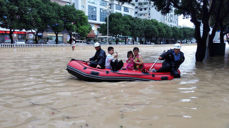 People take a boat at a flooded area as Typhoon Megi lands in Fuzhou, Fujian province, China, September 28, 2016. REUTERS/Stringer