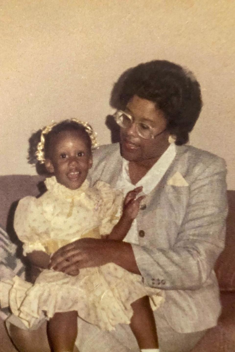 A woman holds a young girl on her lap