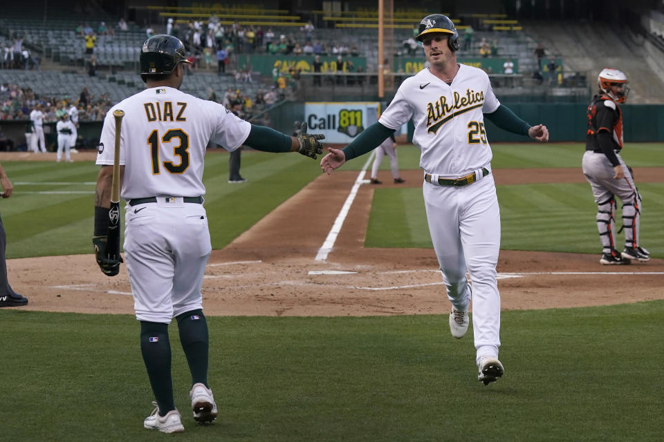 Oakland Athletics' Brent Rooker, front right, is congratulated by Jordan Diaz, left. after scoring against the Baltimore Orioles during the first inning of a baseball game in Oakland, Calif., Friday, Aug. 18, 2023. (AP Photo/Jeff Chiu)