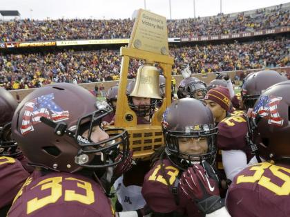 Minnesota Players carry the Governor's Victory Bell trophy after beating Penn State in 2013. (AP)