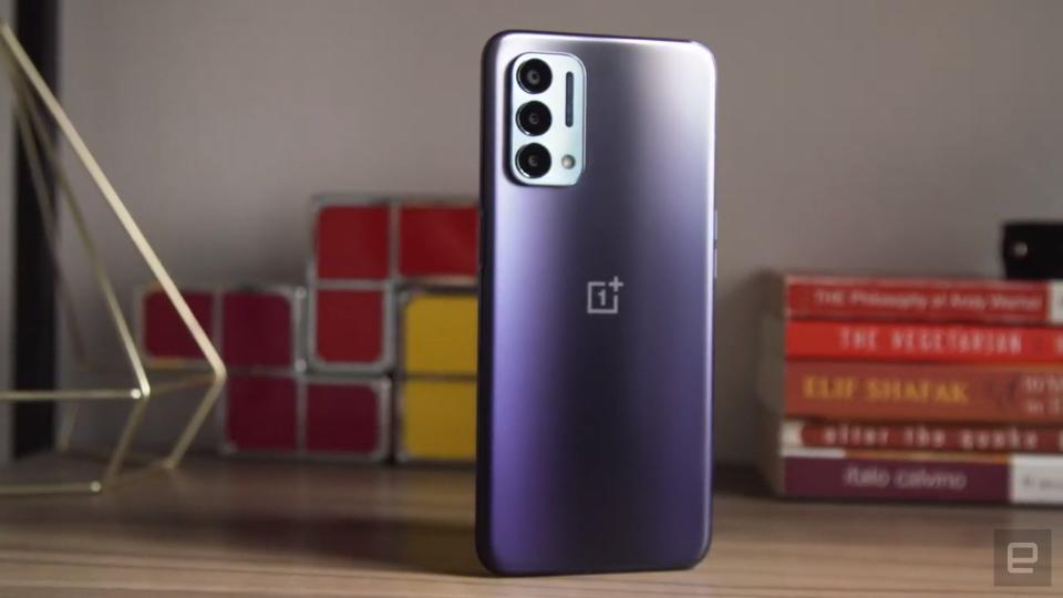 <p>OnePlus Nord N200 5G review picture. Off angle view of the phone sitting on a shelf with ornaments in the background with its rear facing outwards. </p> 