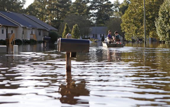 Kyle Hawley, right, and Trey Wood, pilot their boat through the flooded streets of their neighborhood in Greenville, N.C. on  Oct. 12, 2016.