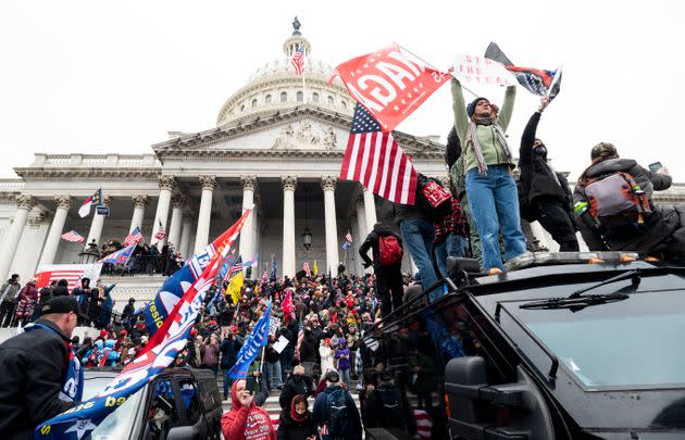 Trump supporters stand on a U.S. Capitol Police armored vehicle as others take over the steps of the Capitol on Jan. 6, 2021. (Photo: Bill Clark via Getty Images)