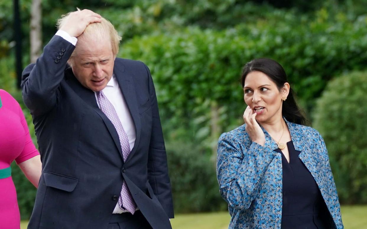 British Prime Minister Boris Johnson and Home Secretary Priti Patel talk during a visit to Surrey Police headquarters - POOL/Reuters