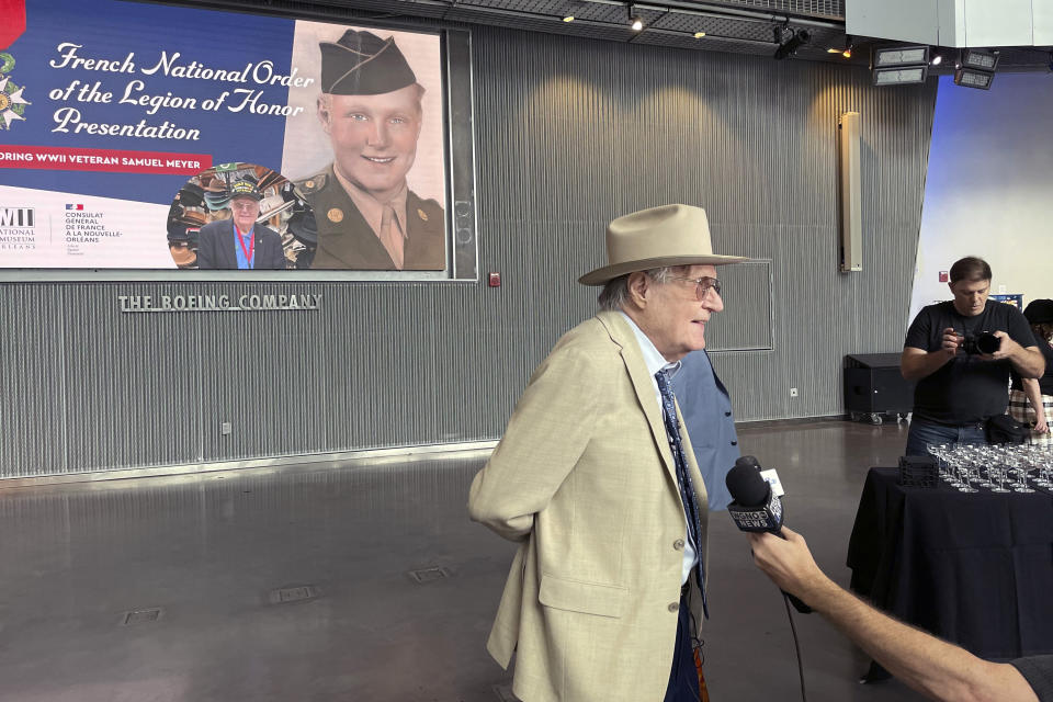 WWII veteran Samuel Meyer, 99, speaks with reporters after being awarded with the rank of chevalier, or knight, in the French Legion of Honor, on Tuesday, Feb. 27, 2024, at the National WWII Museum in New Orleans. Meyer is best known in New Orleans as the longtime proprietor of Meyer the Hatter, a landmark hat business begun by his grandfather in 1894. (AP Photo/Kevin McGill)