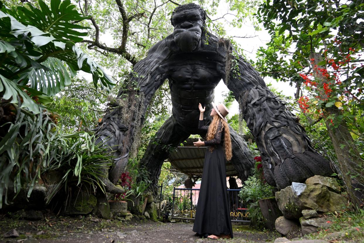 Mariana Camacho shows a sculpture made with recyclable materials by Colombian artist Edison Camacho in the Tire Museum, in San Francisco de Sales, Colombia, on March 31, 2023. The museum was born as a family business and began as an exhibition of sculptures made with recycled material as tires to raise awareness in society about environmental pollution and transform garbage into art.