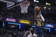 Indiana Pacers' Bennedict Mathurin (00) puts up a shot against Philadelphia 76ers' Joel Embiid (21) during the first half of an NBA basketball game, Monday, March 6, 2023, in Indianapolis. (AP Photo/Darron Cummings)