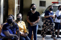 Women wait for a public testing for the new coronavirus conducted at a market in Bali, Indonesia on Friday, June 12, 2020. (AP Photo/Firdia Lisnawati)