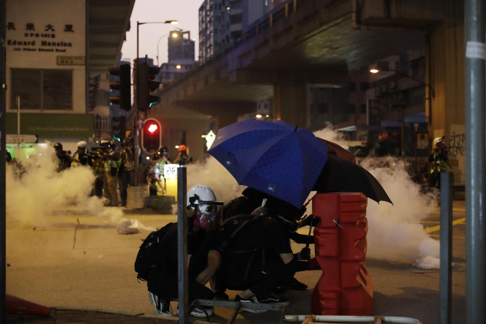 Protestors face police tear smoke in Hong Kong, Sunday, Oct. 20, 2019. Hong Kong protesters again flooded streets on Sunday, ignoring a police ban on the rally and setting up barricades amid tear gas and firebombs. (AP Photo//Mark Schiefelbein)