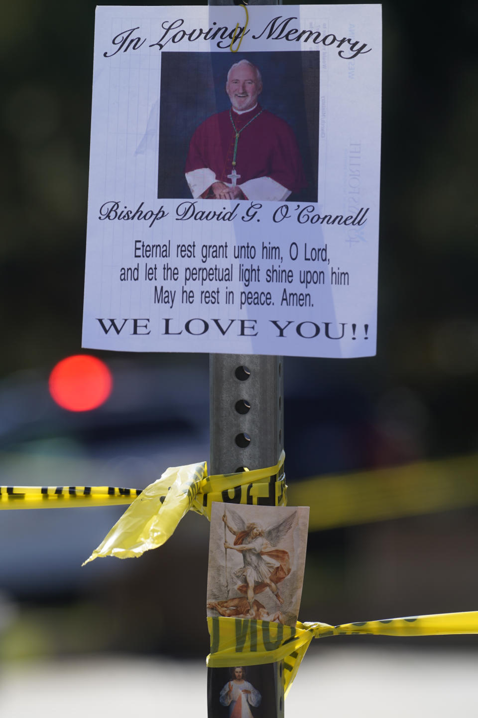 An image of Bishop David O'Connell is posted on the post of a street sign near his home in Hacienda Heights, Calif., Sunday, Feb. 19, 2023. O'Connell was shot and killed Saturday just blocks from a church, a slaying of a longtime priest hailed as a “peacemaker” that's stunned the Los Angeles religious community, authorities said. Detectives are investigating the death as a homicide, according to the Los Angeles County Sheriff's Department. (AP Photo/Damian Dovarganes)