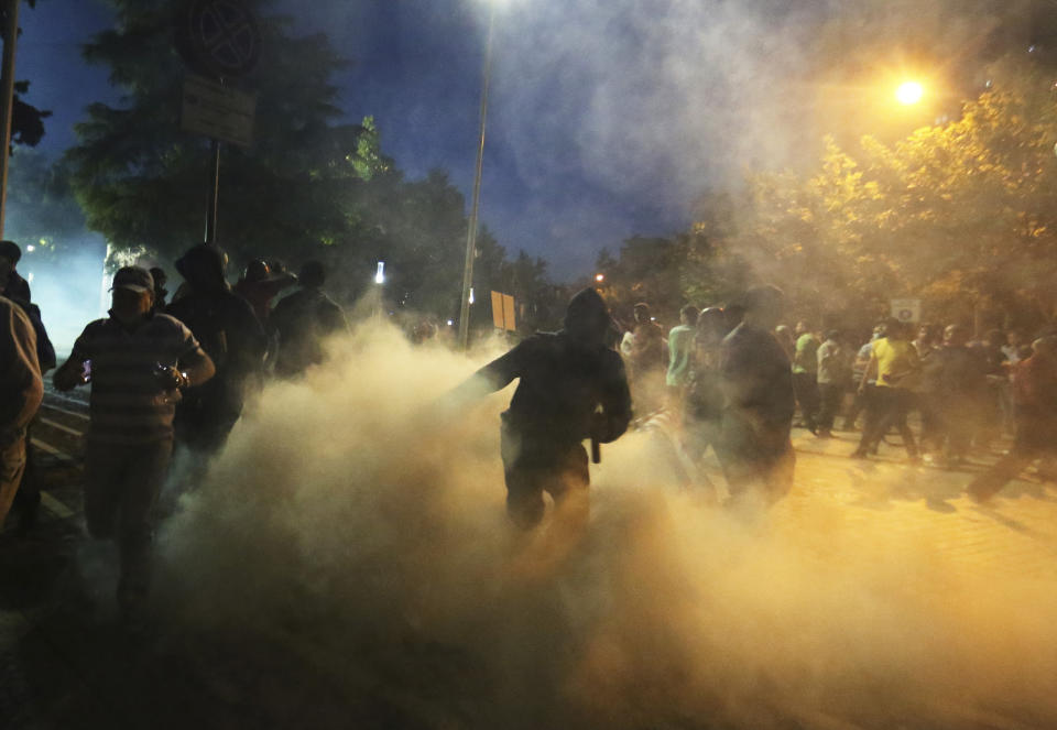 Demonstrators make their way through a cloud of tear gas during an anti-government protest in Tirana, Albania, Saturday, June 8, 2019. Thousands of Albanian opposition supporters are gathering in an anti-government protest while the United States and the European Union caution their leaders to disavow violence and sit in a dialogue to overcome the political crisis. (AP Photo/Hektor Pustina)