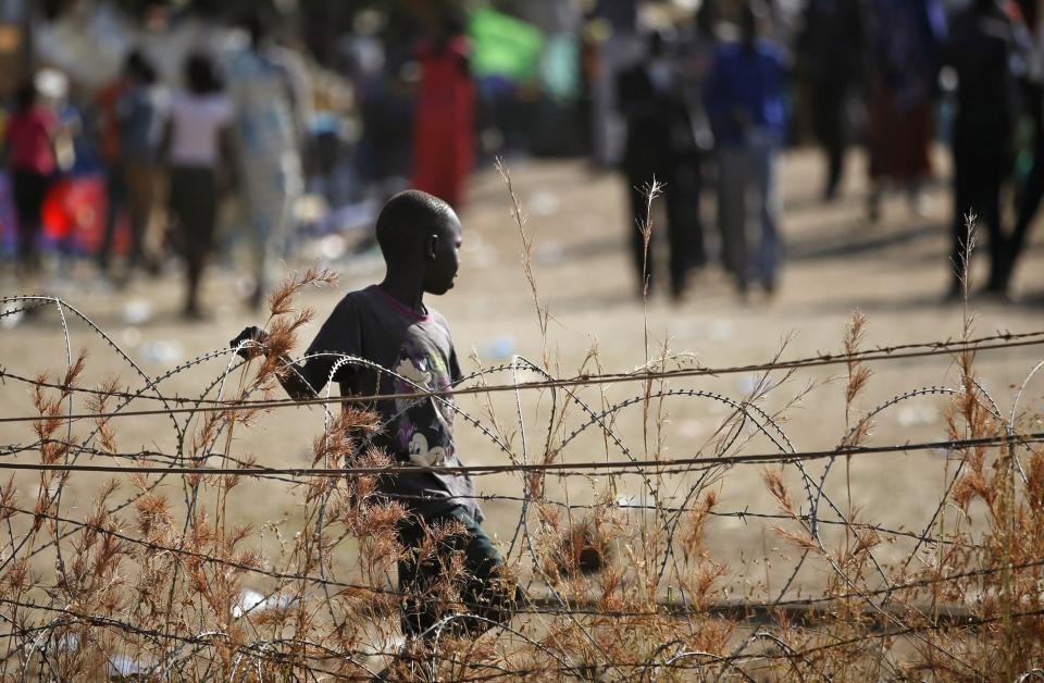 An internally displaced boy walks next to barbed wire inside a UNMIS compound in Juba