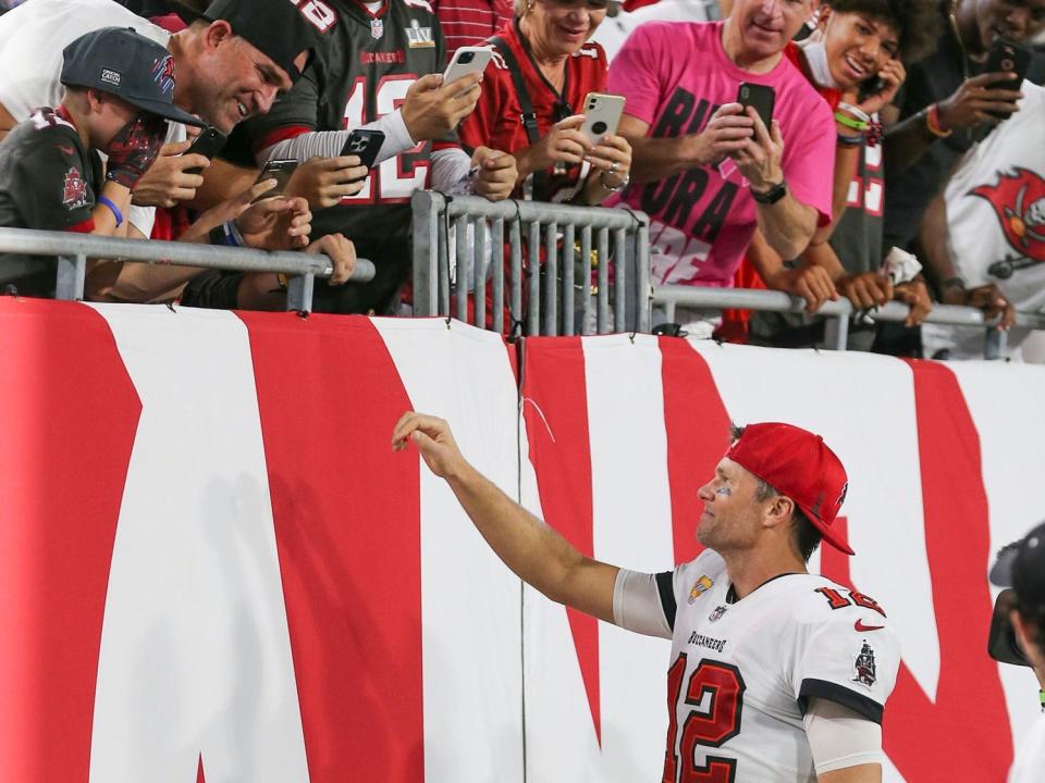 Tom Brady gives his hat to a young fan in the stands during a game against the Chicago Bears.