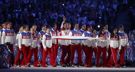 Russia's athletes carry their national flag in the closing ceremony for the Sochi 2014 Winter Olympic Games February 23, 2014. REUTERS/Lucy Nicholson