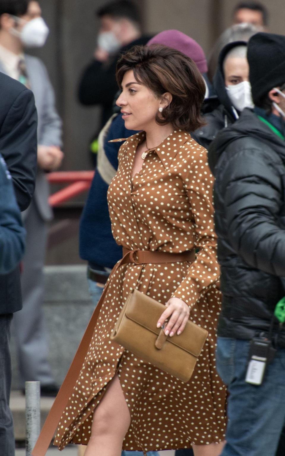 Lady Gaga wears a brown polka dot Max Mara dress on set in Rome - Sipa US / Alamy Stock Photo