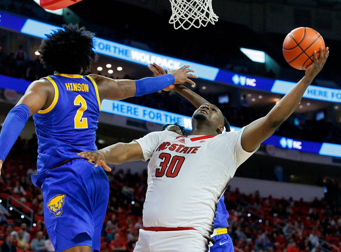 N.C. State’s DJ Burns Jr. drives to the basket around Pittsburgh’s Blake Hinson and Federiko Federiko during the second half of the Wolfpack’s 67-64 loss on Wednesday, Feb. 7, 2024, at PNC Arena in Raleigh, N.C.