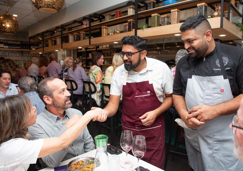 Chefs Pushkar Marathe (right) and Niven Patel greet guests during a 2022 Palm Beach Food & Wine Festival lunch at Marathe's restaurant, Ela.