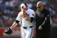 Baltimore Orioles relief pitcher Craig Kimbrel, left, leaves alongside trainer Brian Ebel, right, during the ninth inning of a baseball game against the Oakland Athletics, Sunday, April 28, 2024, in Baltimore. (AP Photo/Nick Wass)