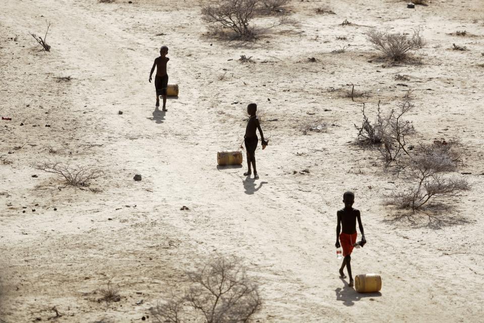 FILE - Young boys pull containers of water as they return to their huts from a well in the village of Ntabasi village amid a drought in Samburu East, Kenya, on Oct, 14, 2022. An international team of climate scientists says the ongoing drought in Eastern Africa has been made worse by human-induced climate change according to a report from World Weather Attribution. (AP Photo/Brian Inganga, File)