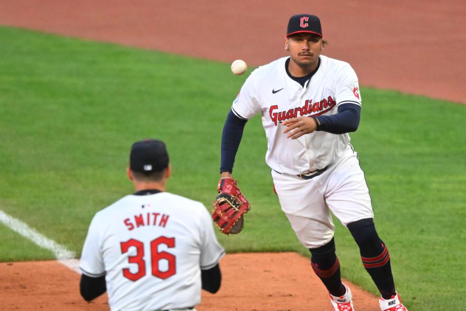 Guardians first baseman Josh Naylor tosses the ball to relief pitcher Cade Smith (36) in the sixth inning against the New York Yankees, April 13, 2024, in Cleveland.