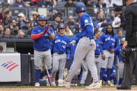 Toronto Blue Jays' Alejandro Kirk, left, greets Ernie Clement (28), front, after Clement hit a home run during the seventh inning of a baseball game against the New York Yankees at Yankee Stadium in New York, Friday, April 5, 2024. (AP Photo/Seth Wenig)