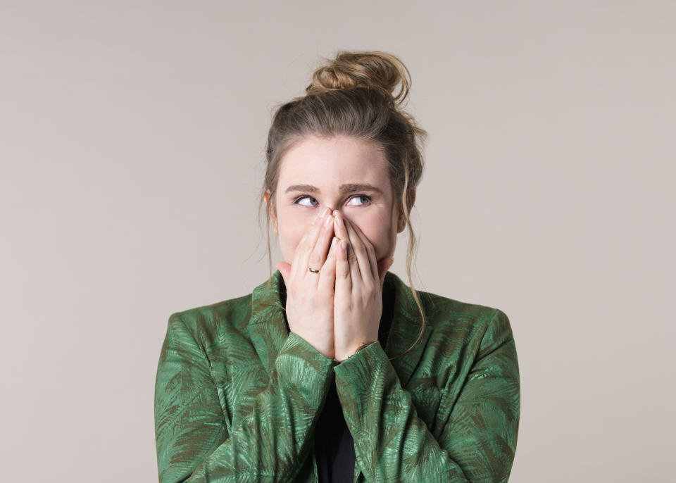 a woman laughing and covering her mouth