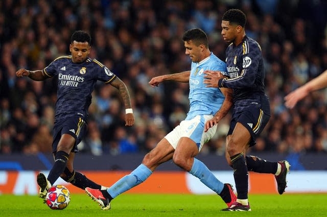 Manchester City’s Rodri (centre) is challenged by Jude Bellingham