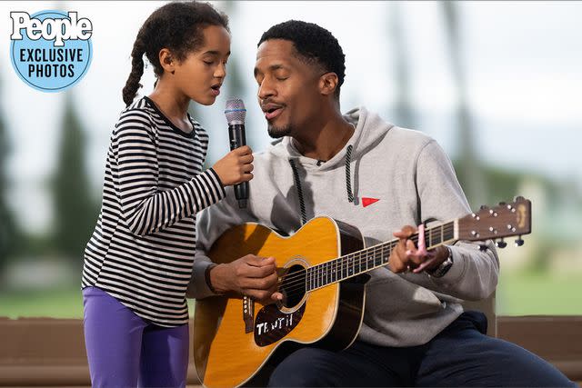 <p>J. Anthony Martinez Photography</p> Ron Artis II sings with a student in Hawaii