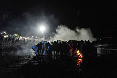 Police use a water cannon to put out a fire started by protesters during a protest against plans to pass the Dakota Access pipeline near the Standing Rock Indian Reservation, near Cannon Ball, North Dakota, U.S. November 20, 2016. REUTERS/Stephanie Keith