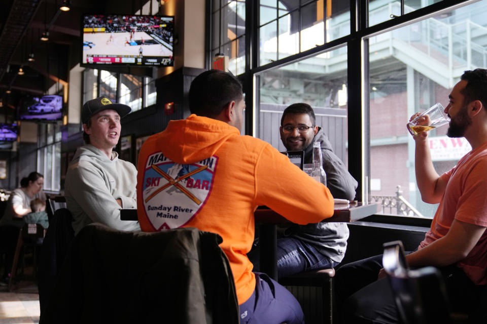 Taylor Foehl, left, of Boston, watches watches the men's basketball game between Rutgers and Purdue after placing a wager on his mobile phone, at the Cask 'N Flagon sports bar, Friday, March 10, 2023, near Fenway Park in Boston. Massachusetts sports fans raced to their cell phones Friday, March 10 to begin placing bets as the state allowed online sports wagering just days ahead of tip-off of the NCAA Tournament next week. (AP Photo/Charles Krupa)