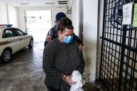 British national Samantha Jones, accused of killing her husband in 2018, is escorted by a police officer as she arrives at a court in Alor Setar, in northern Malaysia, on August 3, 2020. - Jones was arrested two years ago after her husband John William Jones was found with a stab wound to his chest in his house on the Malaysian holiday island of Langkawi. (Photo by A. Ammarudin / AFP) (Photo by A. AMMARUDIN/AFP via Getty Images)