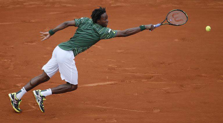 France's Gael Monfils returns the ball to Uruguay's Pablo Cuevas during the men's third round of the Roland Garros 2015 French Tennis Open in Paris on May 29, 2015