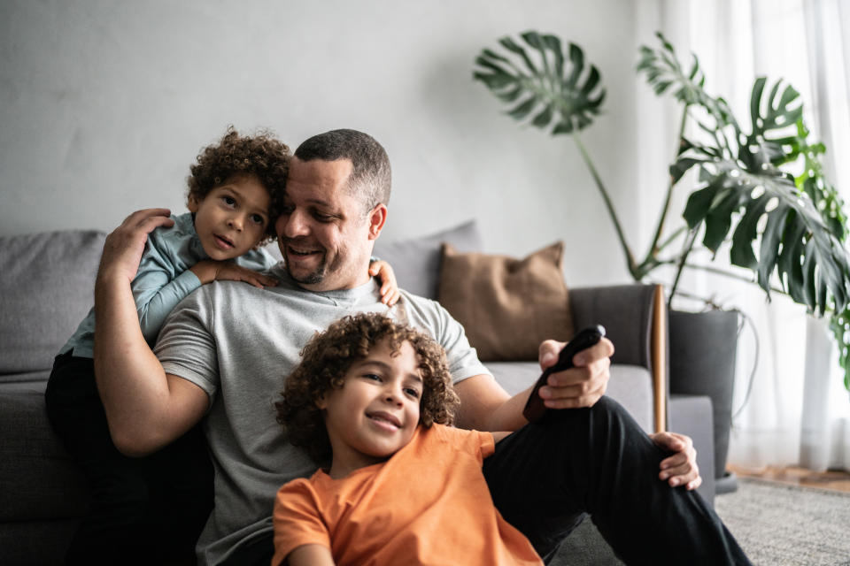 Father and sons watching TV at home