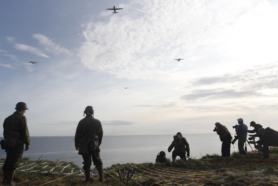 Planes fly over as Rangers of the U.S. 75th Ranger Regiment, in period dress stand on the overlook after climbing the cliffs of Pointe-du-Hoc in Cricqueville-en-Bessin, Normandy, France, Wednesday, June 5, 2019. During the American assault of Omaha and Utah beaches on June 6, 1944, U.S. Army Rangers scaled the 100-foot cliffs to seize German artillery pieces that could have fired on the American landing troops. (AP Photo/Thibault Camus)