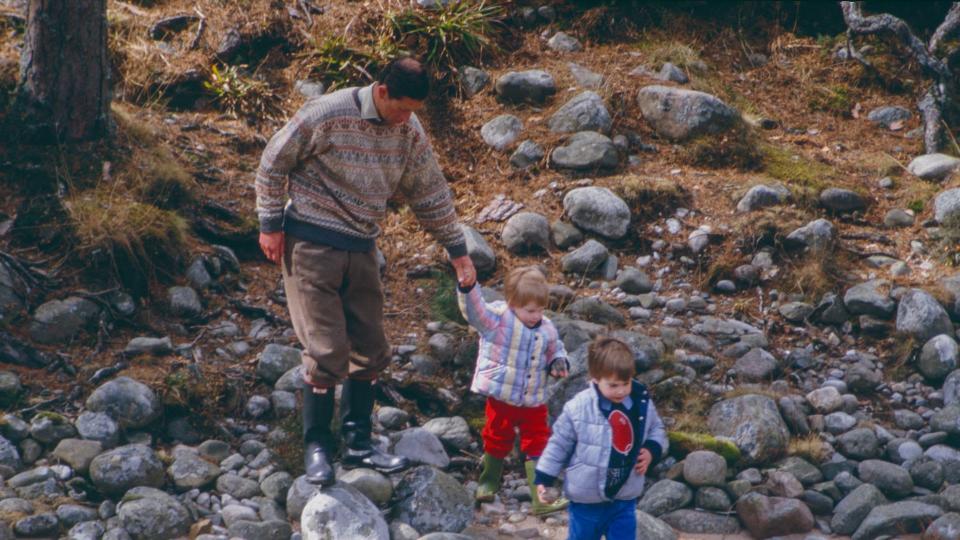 Charles, Prince of Wales, Prince William, and Prince Harry play on the bank of the River Dee, near Balmoral Estate, Scotland, on April 10,1987, in Ballater, Scotland.