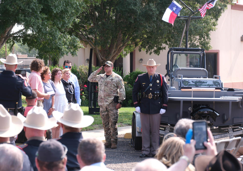 The family of Matthew Myrick stands as the boat is officially dedicated to the fallen trooper Friday morning at the Texas Panhandle War Memorial Center in Amarillo.