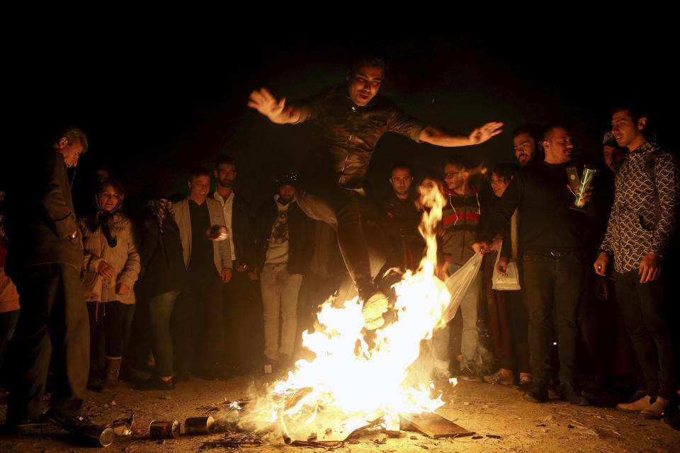 An Iranian man jumps over a bonfire during a celebration, known as "Chaharshanbe Souri," or Wednesday Feast, marking the eve of the last Wednesday of the solar Persian year, Tuesday, March 19, 2019 in Tehran, Iran. Iran's many woes briefly went up in smoke on Tuesday as Iranians observed a nearly 4,000-year-old Persian tradition known as the Festival of Fire. (AP Photo/Ebrahim Noroozi)