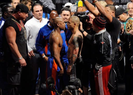 Floyd Mayweather (L) and WBA super welterweight champion Miguel Cotto face off during the official weigh-in for their bout at the MGM Grand Garden Arena, on May 4, in Las Vegas, Nevada. Cotto defends his title on May 5