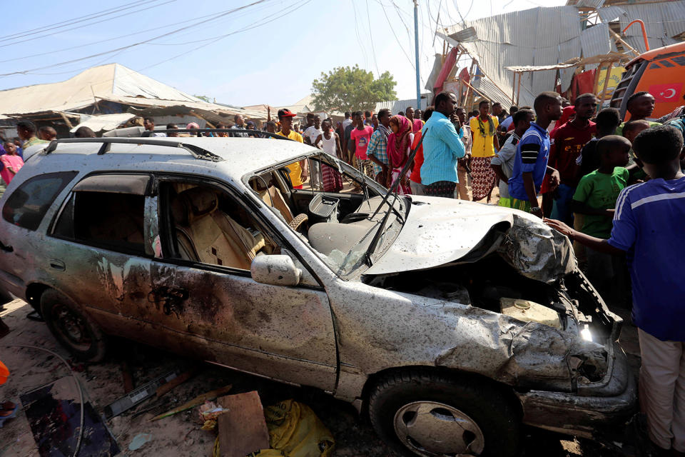 <p>Civilians stand near a car destroyed in a suicide bomb explosion at the Wadajir market in Madina district of Somalia’s capital Mogadishu, Feb. 19, 2017. (Photo: Feisal Omar/Reuters) </p>