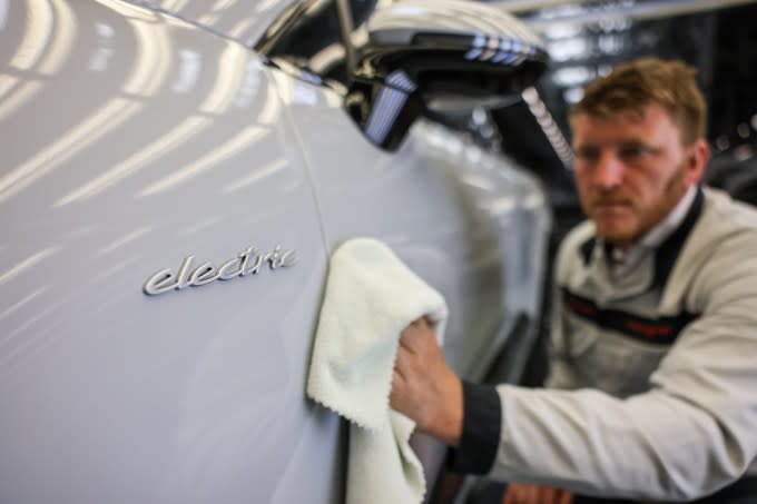 A Porsche employee checks an all-electric Porsche Macan in quality control at its Leipzig plant.