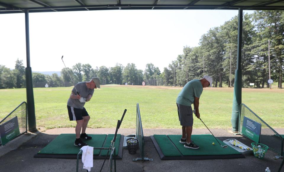 Michael Barocas, 79, of Mount Kisco, left, hits golf balls on the driving range at Mohansic Golf Course in Yorktown Heights July 21, 2022. Barocas believes that the new state law banning smoking on public golf courses shows an inconsistency in laws regarding pollution, saying "how can you get bent out of shape from the smoke from a cigarette if you're driving a car", which he points out if far more polluting than smoking. 