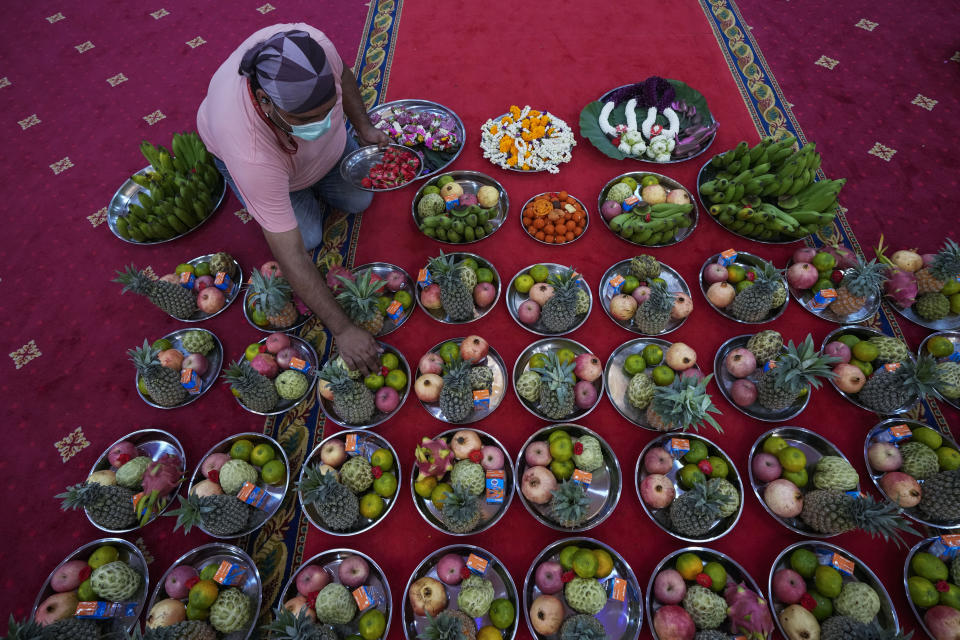 A devotee prepares fruits and flower offerings to Hindu Goddess Lakshmi during the Hindu festival of lights, Diwali at Vishnu temple in Bangkok, Thailand, Thursday, Nov. 4, 2021. Millions of people across Asia are celebrating the Hindu festival of Diwali, which symbolizes new beginnings and the triumph of good over evil and light over darkness. (AP Photo/Sakchai Lalit)