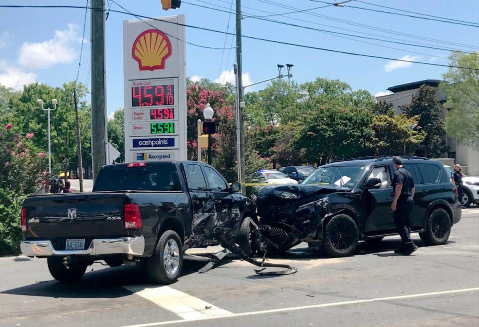 A black Infiniti SUV, right, and a Dodge Ram 1500 pickup truck block the intersection of South and East Boulevards in Charlotte, NC, on Wednesday, July 6, 2022. Charlotte-Mecklenburg police announced charges against two individuals in connection with the police pursuit.