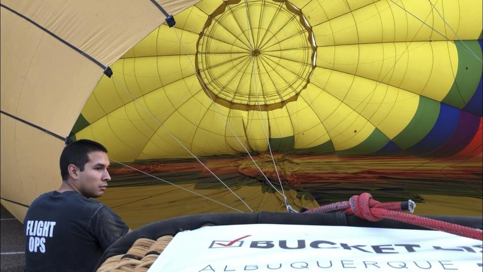 Elijah Sanchez helps inflate a hot air balloon in Albuquerque, N.M., on Tuesday, Oct. 1, 2019. Sanchez, 20, will be among the youngest pilots to launch as part of this year's Albuquerque International Balloon Fiesta. The nine-day event is expected to draw several hundred thousand spectators and hundreds of balloonists from around the world. It will kick off Oct. 5 with a mass ascension. (AP Photo/Susan Montoya Bryan)