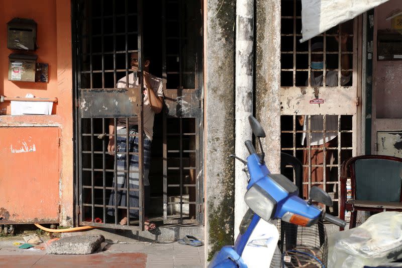 Rohingya refugees look out from their homes in Kuala Lumpur