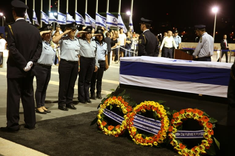 Israeli policewomen salute in front of the coffin of former Israeli president Shimon Peres at the plaza outside the Knesset on September 29, 2016